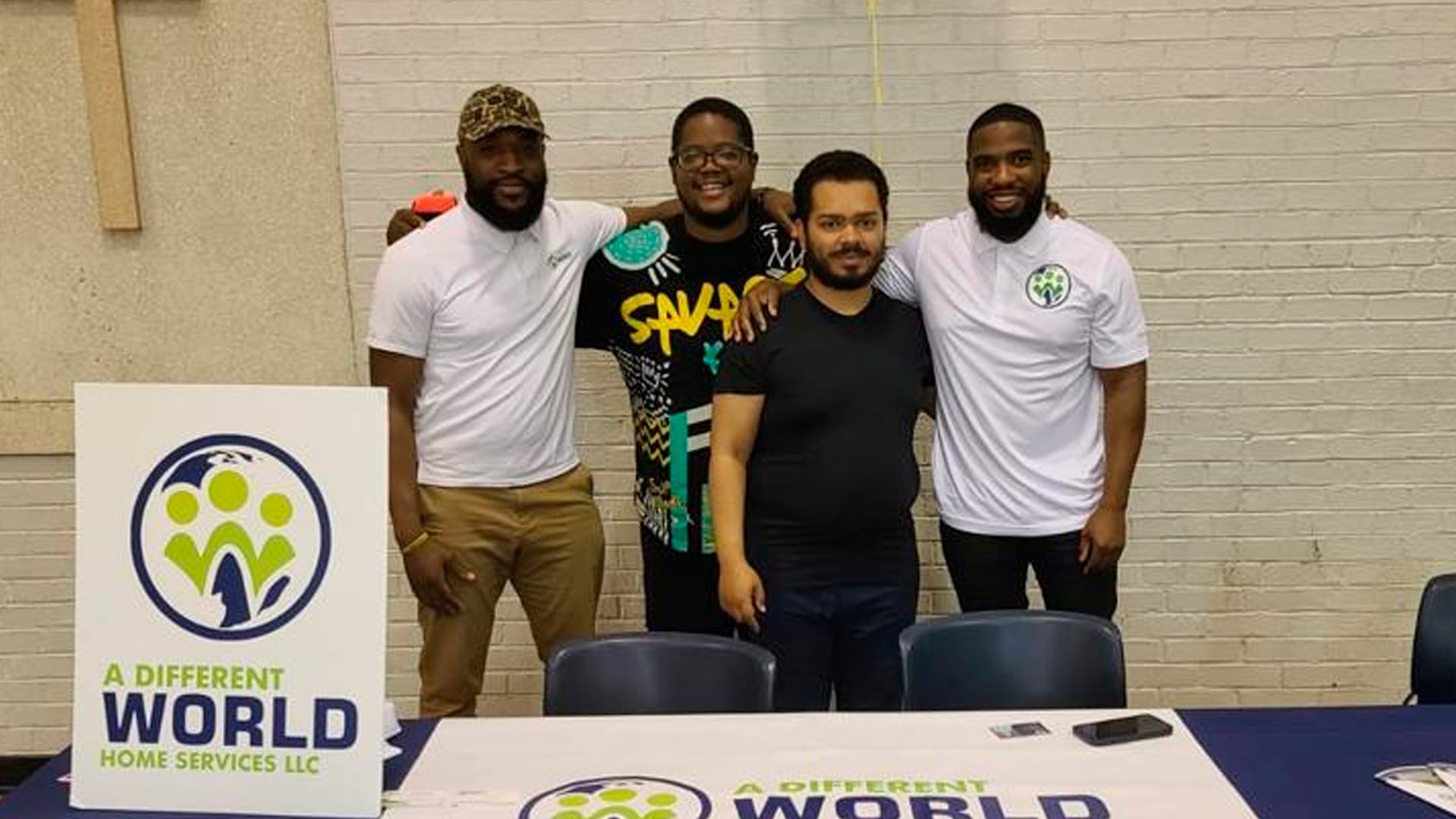 Our History at A Different World Services captured in a photo of four team members standing together at an event, showcasing their commitment to empowering individuals with disabilities.